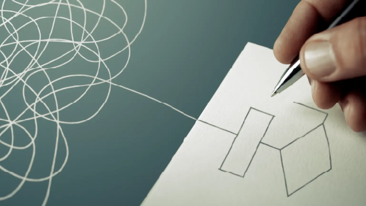 Hand drawing a flowchart starting from a tangled mess of lines, symbolizing organization.